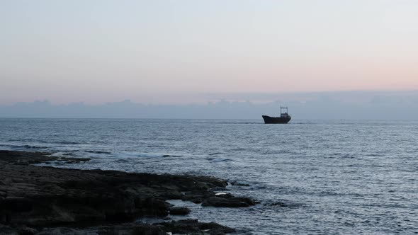 Old Rusty Ship Stranded at Rocky Seashore. 