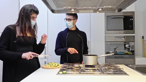 Young couple cooking together in a medical mask. Social distancing. Quarantine time.