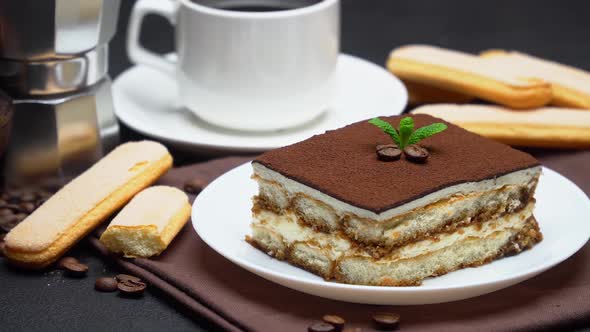 Portion of Traditional Italian Tiramisu dessert, mocha coffee maker, cup of espresso