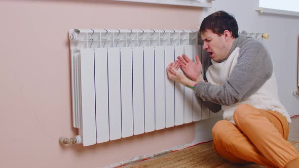 Man Warming Hands on Radiator