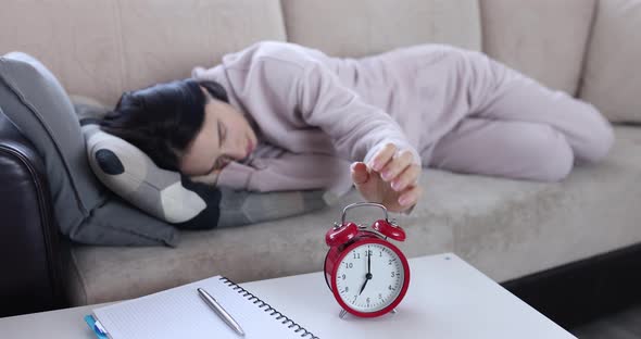 Sleeping Woman Turns Off Alarm While Lying on Couch