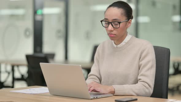 Creative African Woman with Laptop Looking at Camera