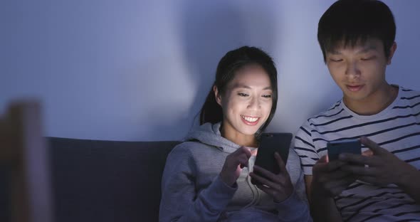 Husband and wife using cellphone at home