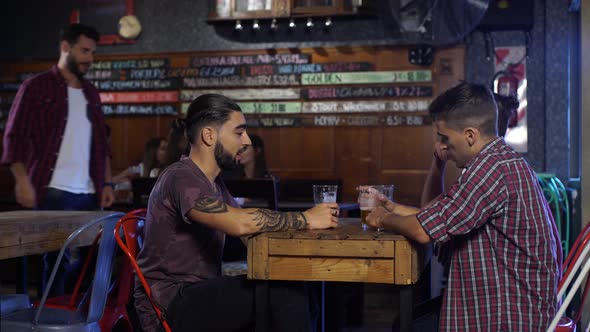 Guy joins with his friends to drink a beer at a bar in Patagonia Argentina