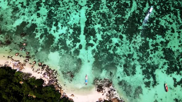 Aerial Overhead Flying Over Sunset Beach With Turquoise Waters With Coral. Dolly Forward