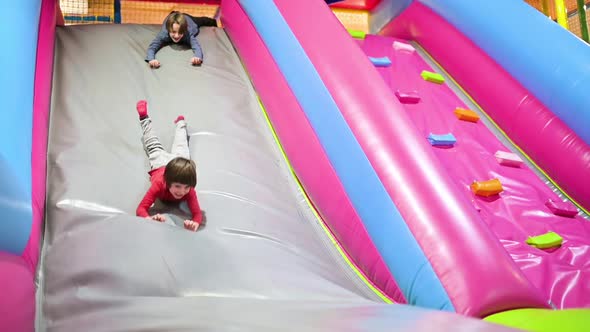 Funny Boys Playing on Inflated Slide