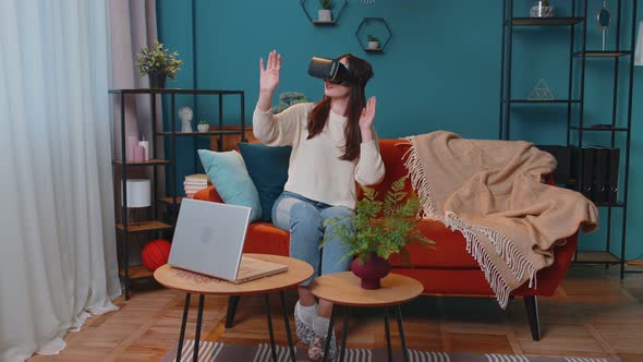 Young Woman Use Virtual Reality Headset Glasses at Home Enjoying Video Concept Moving Hands in Air