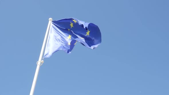 EU flag in front of blue sky slow waving on wind slow motion 1080p HD footage -  European Union flag