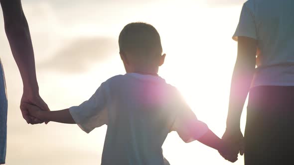 People Together Hold Hands at Sunset