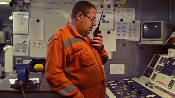 Marine Engineer Working on Radio Communication at Engine Control Room