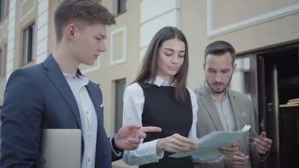 Young Woman and Two Men in Formal Wear Walking on Terrace Discussing Project. Concept of Freelance