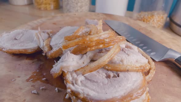 Slider Shot of Sliced Belly Pork Joint with Crispy Crackling on a Wooden Cutting Board in the Kitche