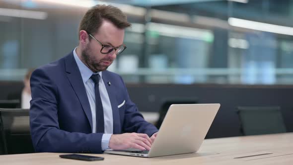 Middle Aged Businessman Working on Laptop
