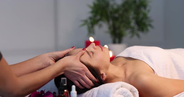 Masseuse Makes Face Massage to Woman in Spa Salon