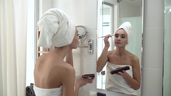 Makeup. Woman Applying Eyeshadows And Looking At Mirror