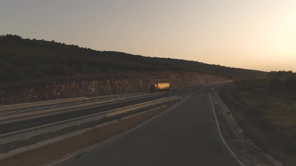 Drone Following Big Cargo Truck on Empty Freeway at Sunset