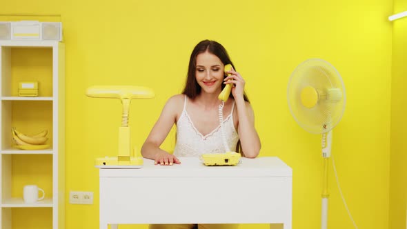 Young Woman Is Talking Phone In Beautiful Yellow Office