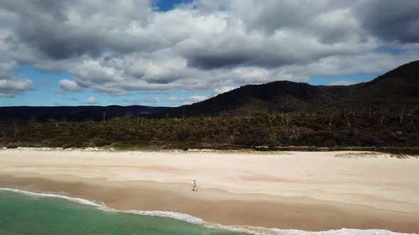 Lost Person Walking Along Beach With White Sand And Waves Rolling In Tasmania, Australia