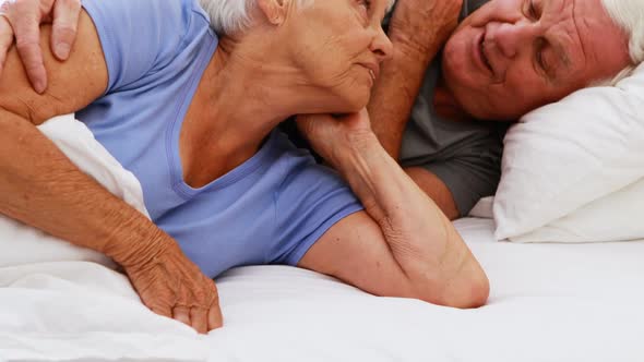 Happy senior couple interacting with each other on bed