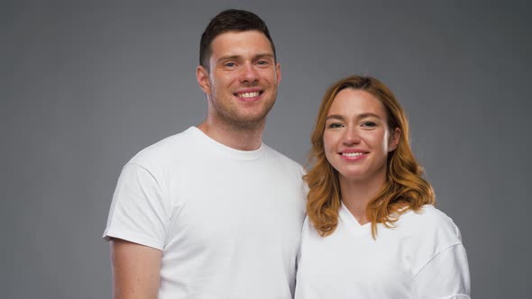 Couple in White T-shirts Over Grey Background