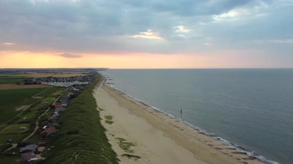 Aerial: Eccles sea beach with fishing village at Norfolk, England - tilt up shot