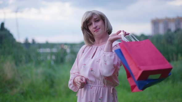 Medium Shot of Fashionable Stylish Trans Woman Hanging Shopping Bags on Shoulder in Slow Motion