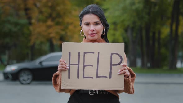 Closeup Sad Young Woman Stands Outdoors Near Roadway Holding Cardboard Sign with Words HELP Upset