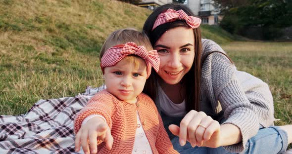 Mother and a Small Daughter, Spends Time Together in a City Park on a Picnic, Young Woman and Little