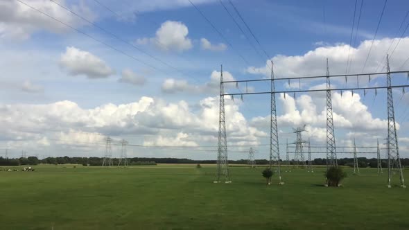 Beautiful landscape of the flat Dutch countryside passing by with electricity poles, cows, crop fiel