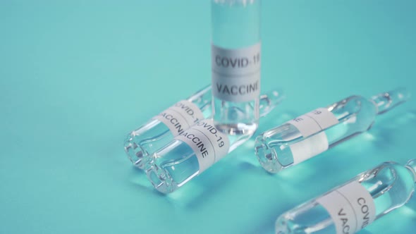 Coronavirus vaccine and COVID-19. A hand in protective gloves sets an ampoule with medicine 