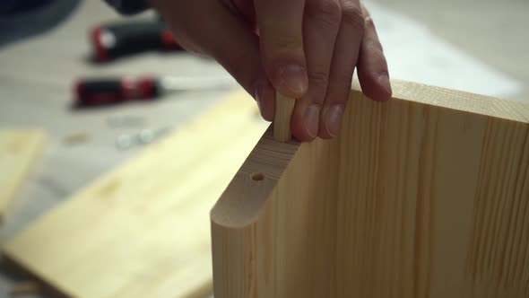 Man Assambles Furniture Screwing Boards with Bolts Closeup Hands