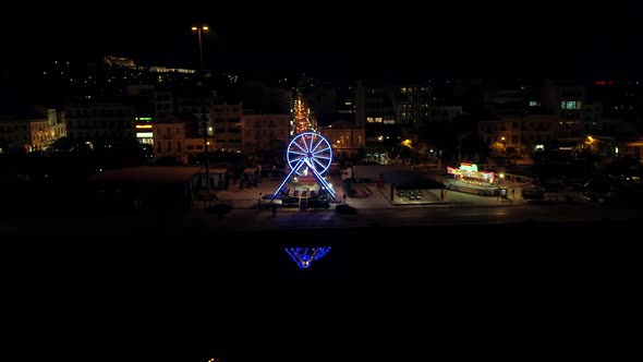 Aerial view of small amusement park with lights at night in Greece.