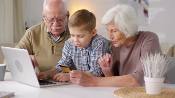 Boy Shopping Online Together with Grandparents