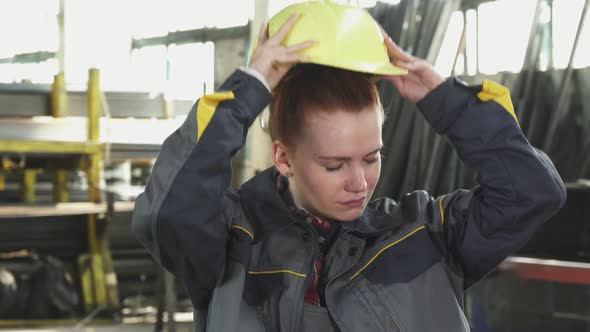 Tired Female Factory Worker Taking off Her Hardhat after Work