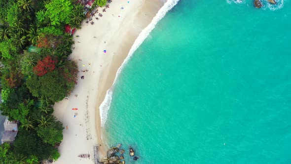 Luxury overhead travel shot of a white sand paradise beach and blue water background in vibrant 4K