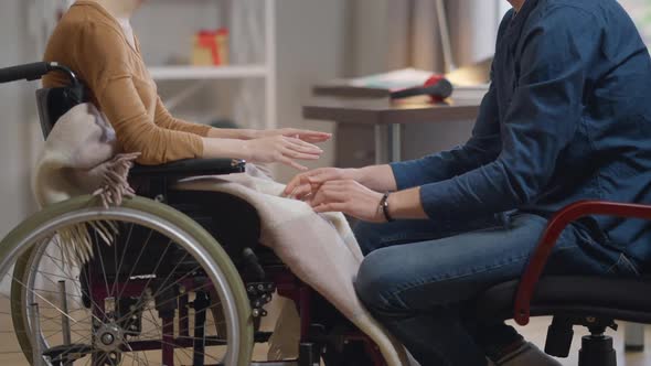 Unrecognizable Disabled Woman Pushing Away Hands of Loving Man Rolling Wheelchair Leaving in Slow