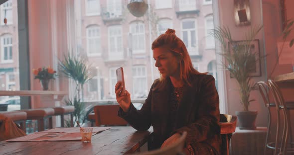 Classy woman facetiming in a bar