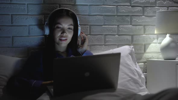 Pretty Asian Woman in Headphone Listening Music at Night, Enjoying Favorite Song