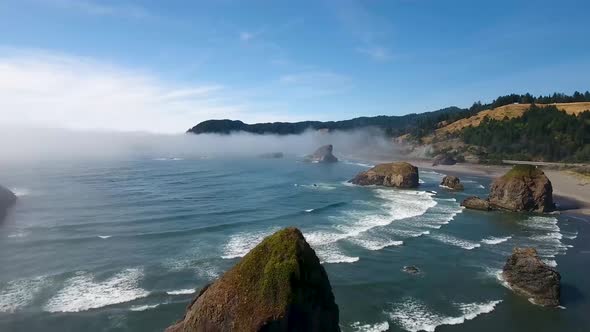 AERIAL: Slow push over rock formations revealing the Oregon coastline.