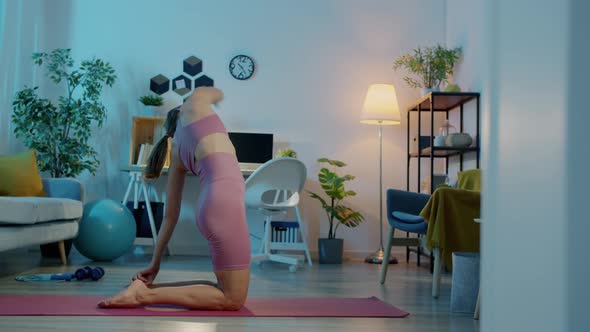 Portrait of Flexible Sportswoman Doing Stretching Exercises Training Alone at Home at Night