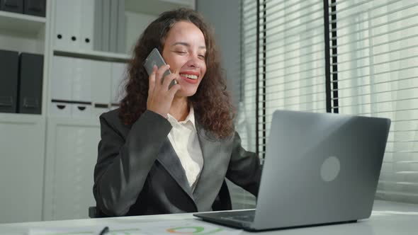 Beautiful Latino business woman dance with music while work in office.