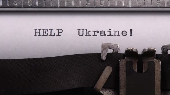 Typing phrase "HELP Ukraine !" on retro typewriter.