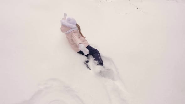 Young Girl in Coral Pink Jacket Walk and Fall to Snow Than Show Snow Angel Butterfly Movement of