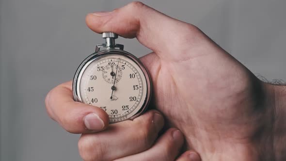 Stopwatch in Male Hand Counts Down Seconds