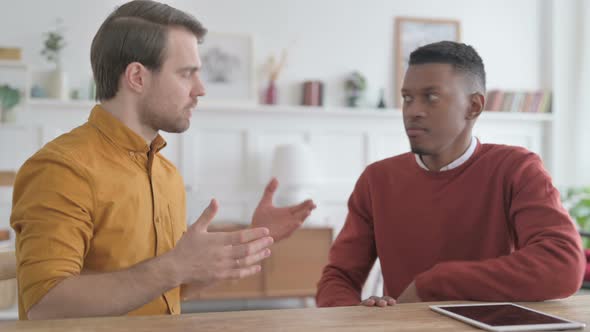 African Man Arguing with Young Man in Office