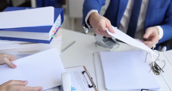 Man and Woman Sorting Documents with Hole Punch and Stapler and Putting Them in Folder  Movie