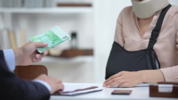 Insurance Agent Giving Euro Money to Injured Woman, Payment for Treatment