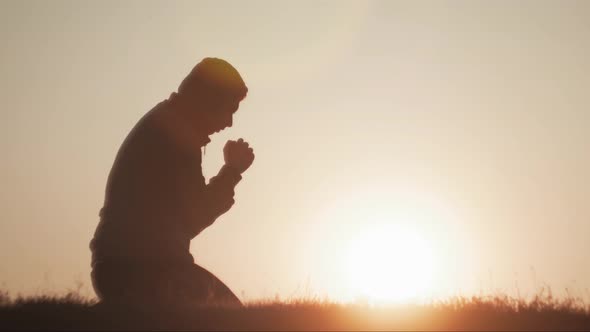 Silhouette Young Man Praying Outside at Beautiful Sunset alt