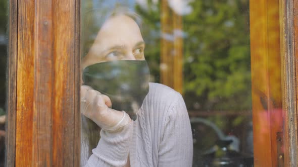 A Girl Quarantined at Home Looking Outside Because of Covid19