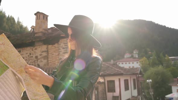 Sun Flare Girl with Touristic Map in Shiroka Laka, Bulgaria. 